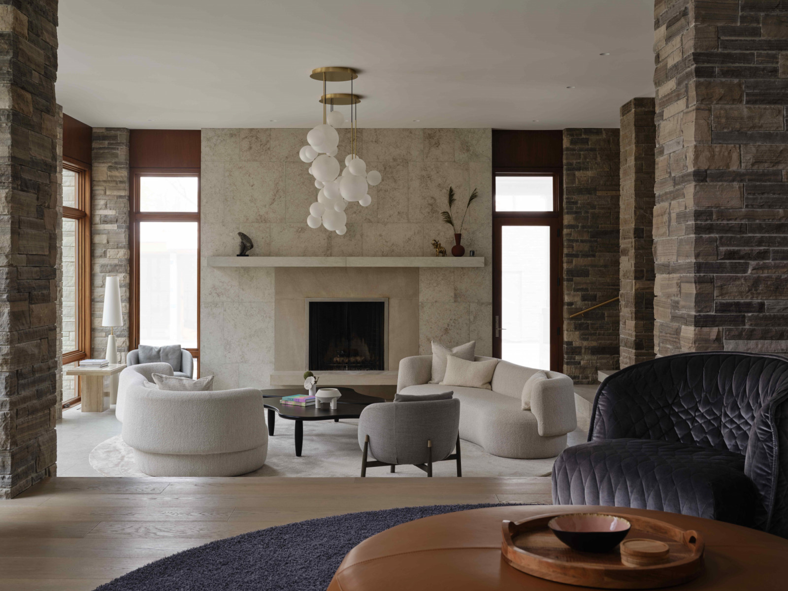 Large expanses of Italian limestone-clad walls establish a calm backdrop in the sunken living room