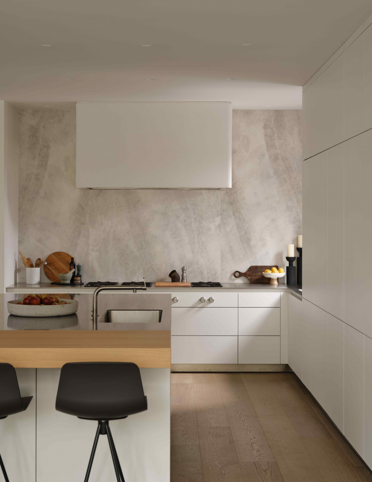 The minimalist kitchen with off-white cabinetry and a custom cooker hood