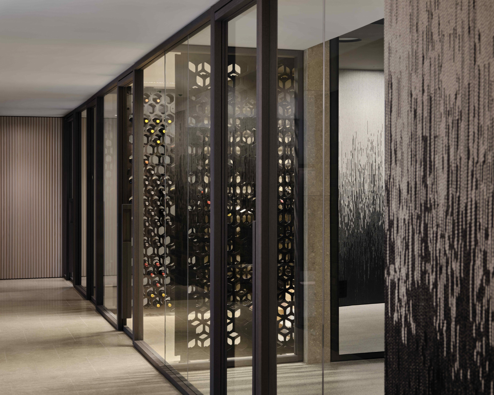 In the basement level, the moody, sunken wine cellar tucked behind a 36-inch glass partition