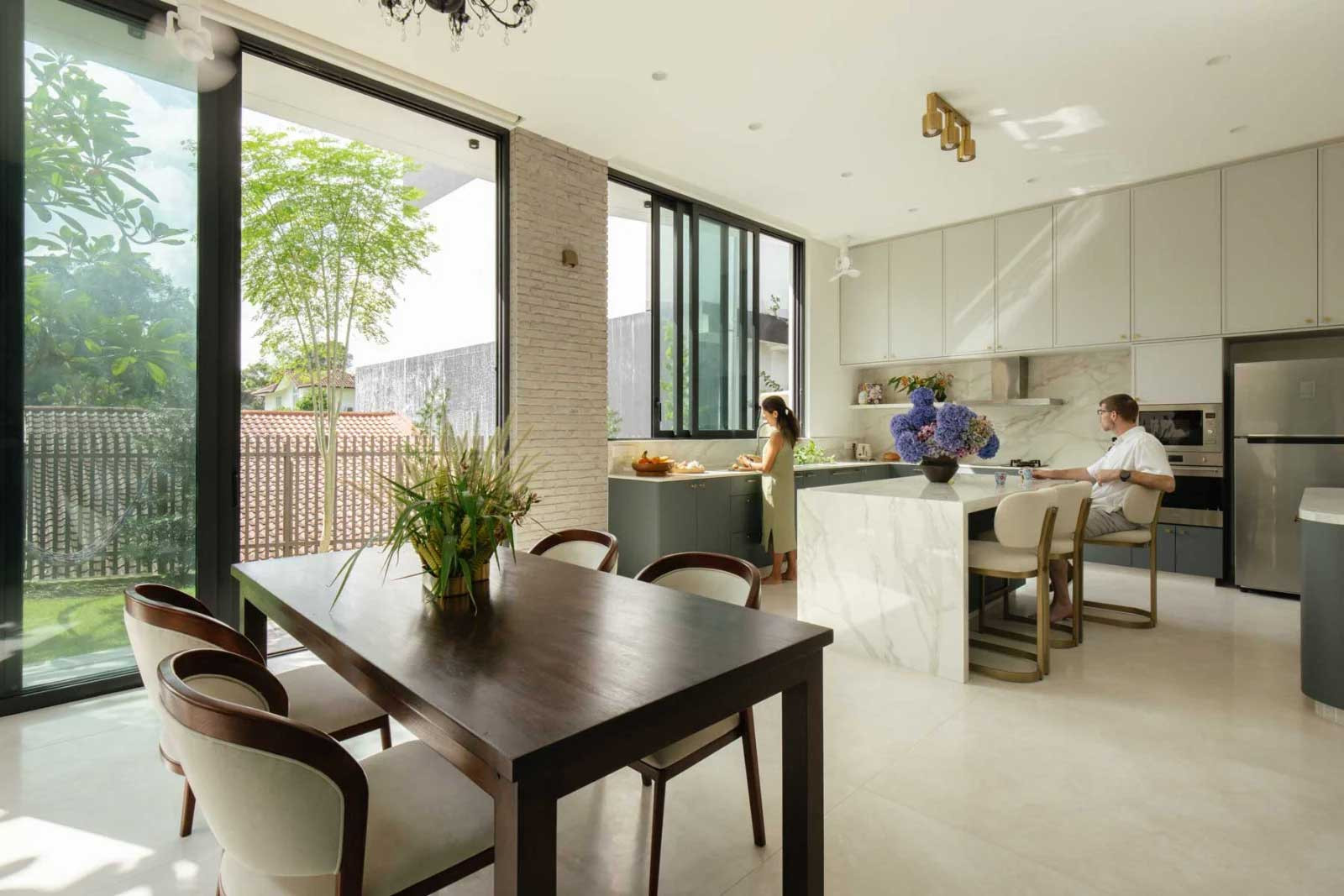 The dining area and kitchen enjoy a seamless connection to the outdoors via large openings and expansive glazing