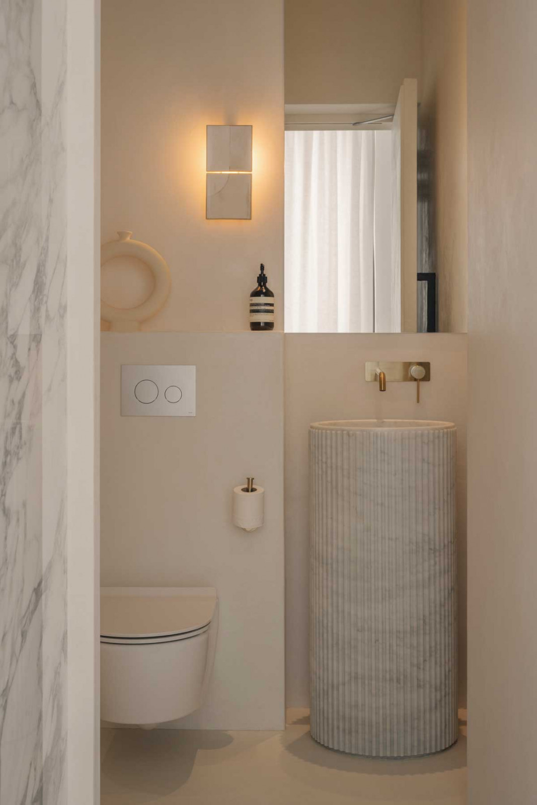 A pedestal washbasin occupies a smaller footprint in this petite powder room