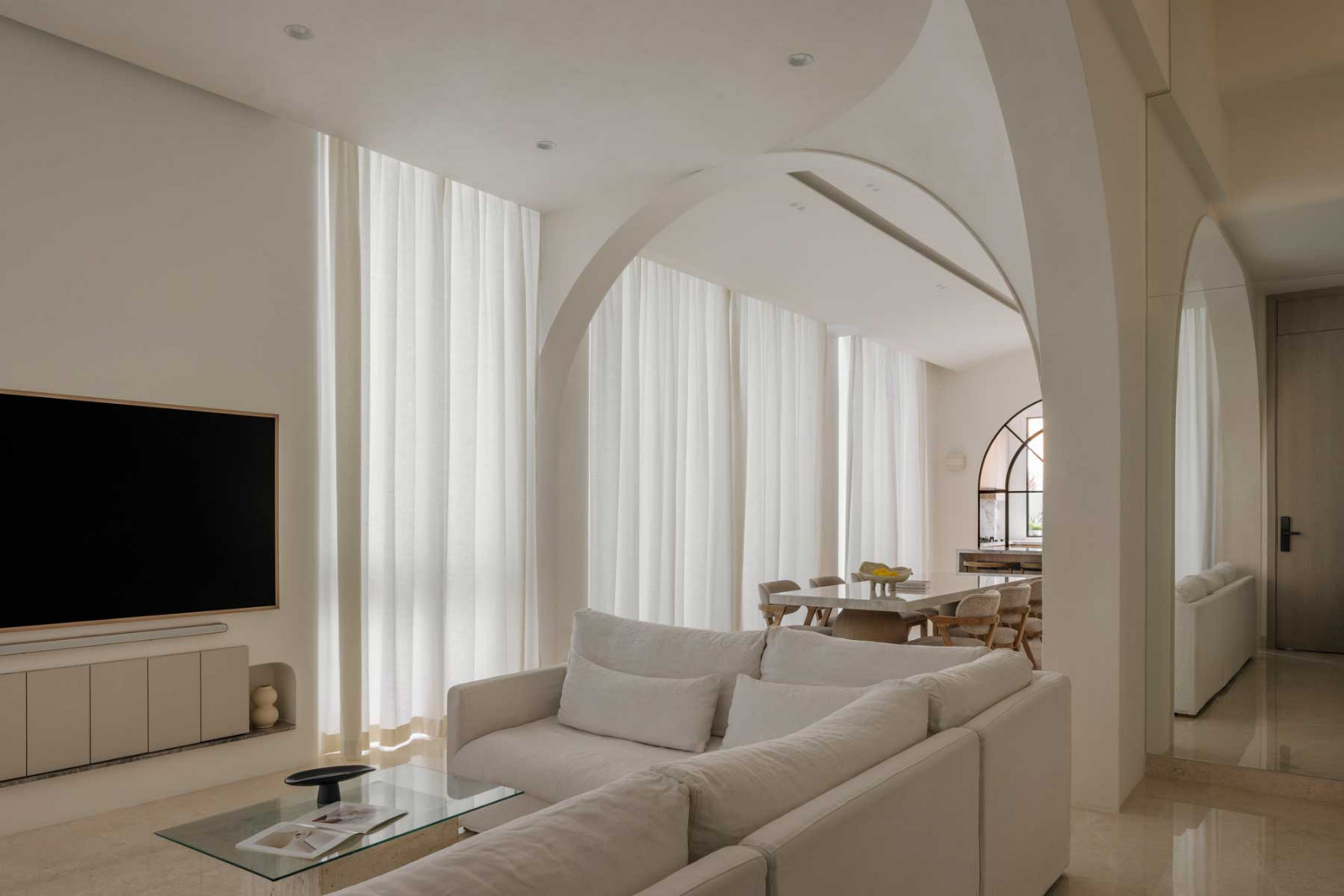 Arches in this terrace hous eby Uncommon Studio create aesthetic appeal and counteract the rigid lines of the home