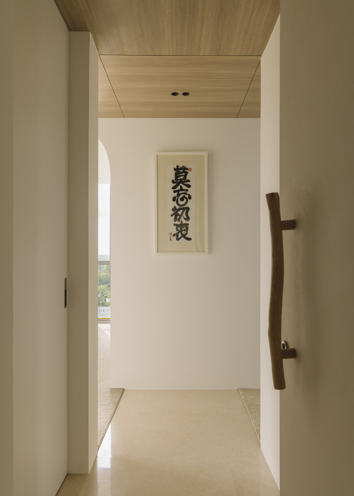 The organic door handle and accompanying calligraphy evoke a poetic mood