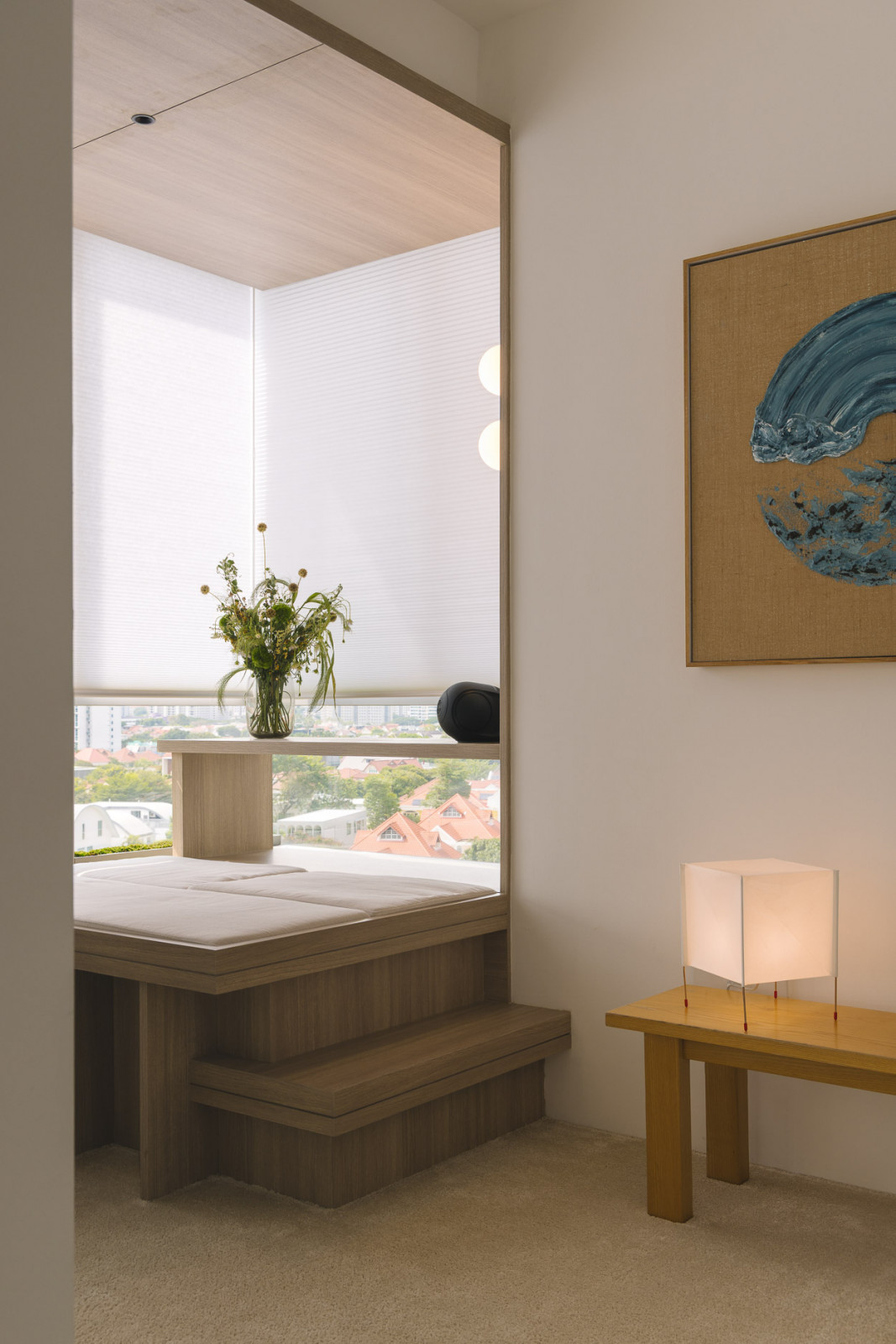 A corner cleverly transformed into an elevated Japanese-style sitting area, while plush carpeting and whitewashed walls make the artwork stand out