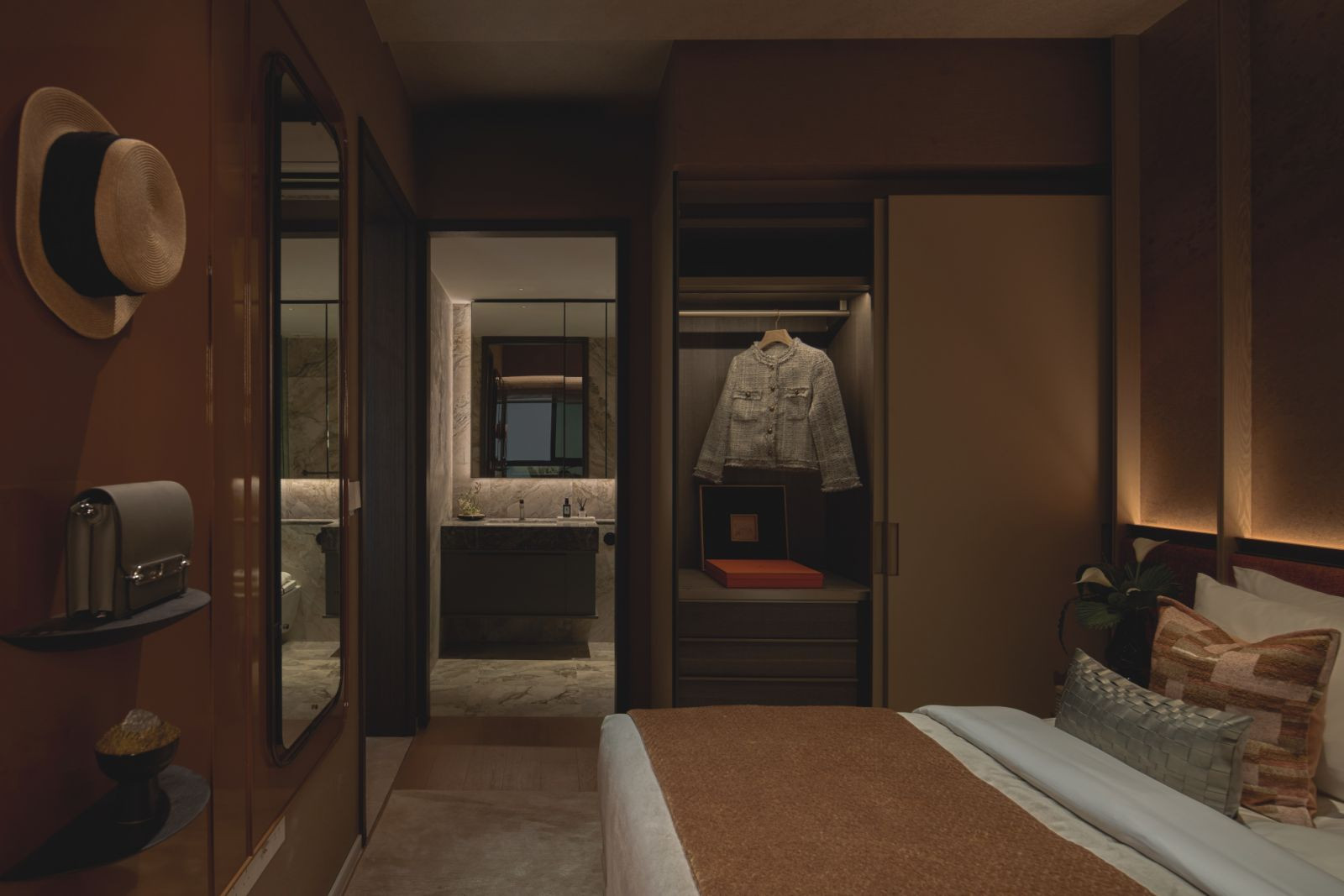 A walk-in wardrobe flows into the en suite, with stone surfaces and muted palettes creating a serene, resort-like experience