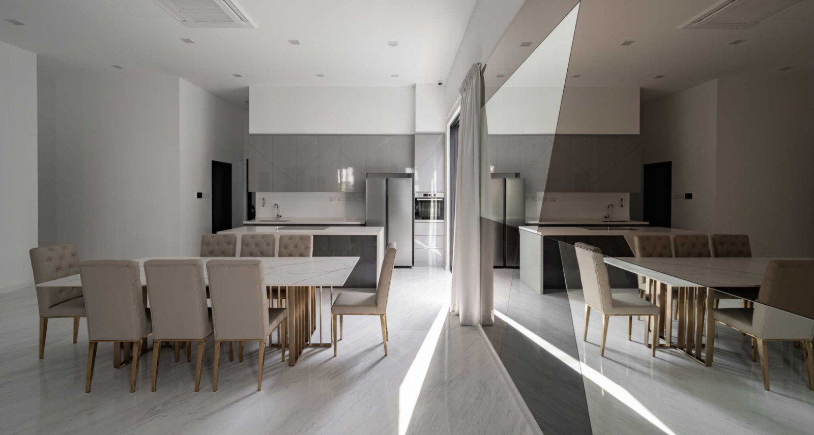 The interplay of various geometric forms and tinted surfaces adds visual interest to the open-plan dining room, especially when sunlight filters in