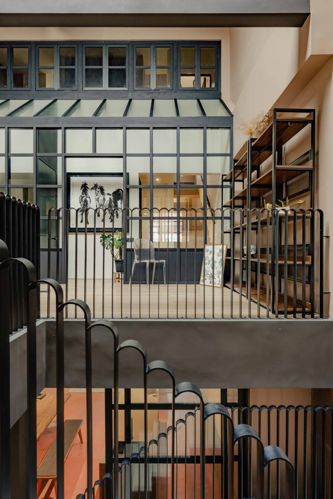 The black curving trellis and steel-framed glazing create a cohesive architectural language, softening the boundary between inside and out while lending the home a subtle glasshouse quality