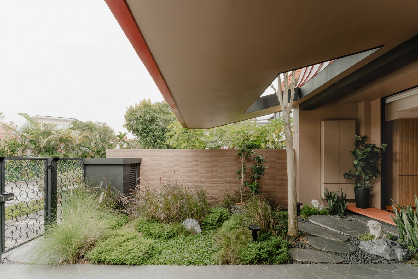 The front garden is planted with long, untamed grass, evoking a sense of cultivated wilderness at the threshold of the house