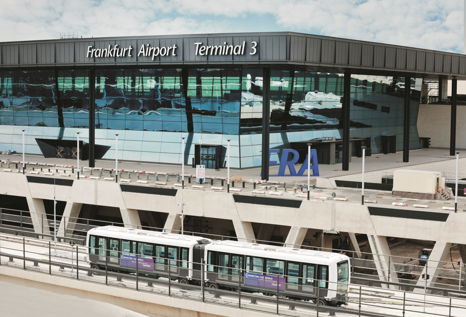The exterior of Frankfurt Airport’s new Terminal 3, designed by Christoph Mäckler, with its glazed facade and elevated Skyline people-mover platform in the foreground