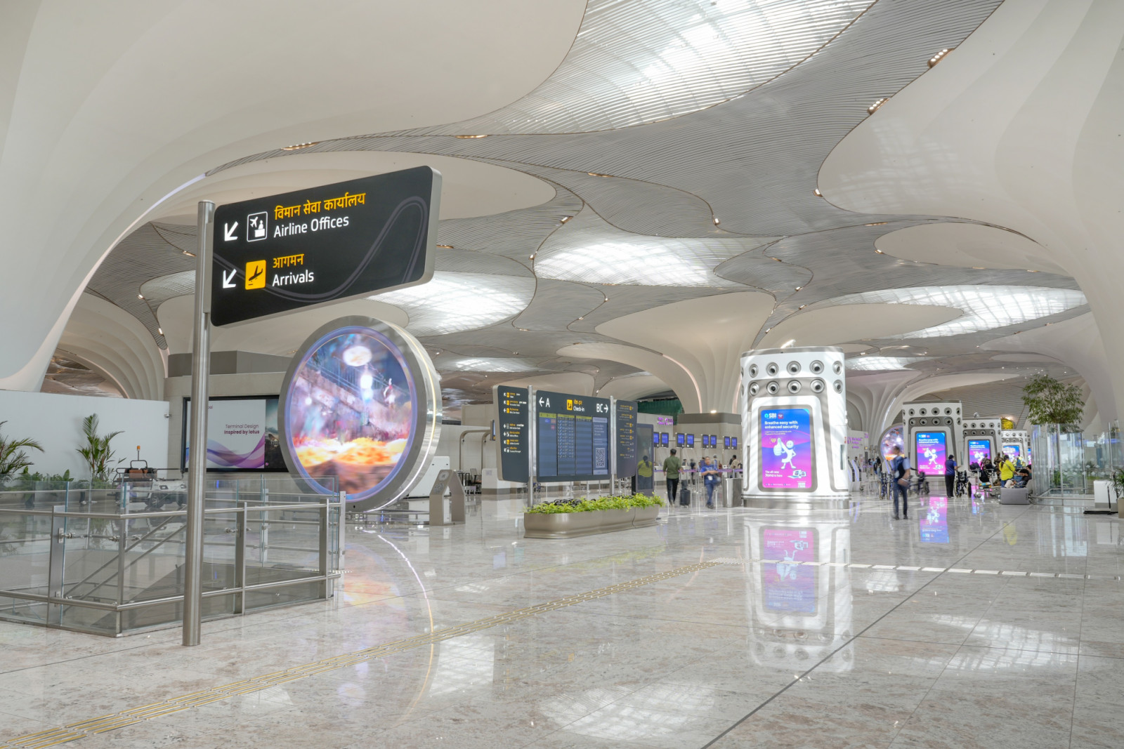 A series of geometric portals choreographs the arrival sequence, extending inward as a continuous ceiling that resolves into the terminal’s signature lotus columns