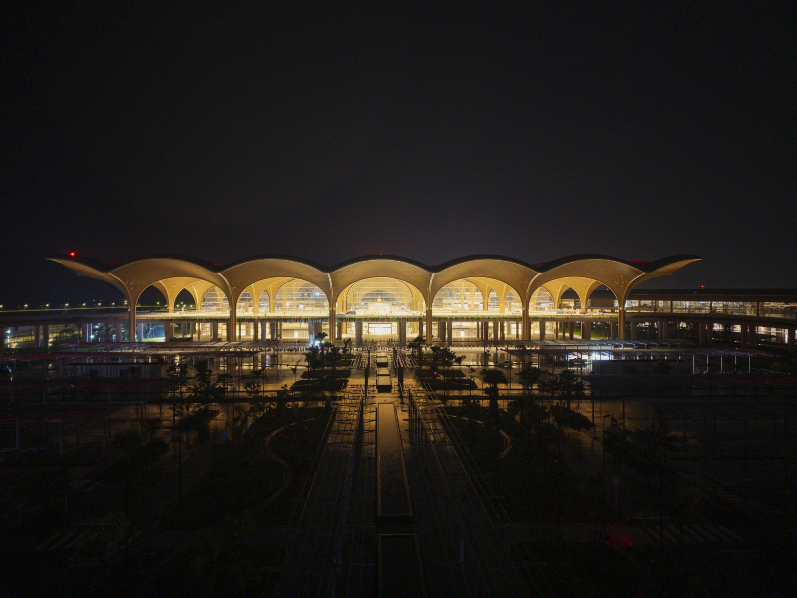 Lit from within at night, the terminal’s row of soaring vaults glows against the dark, their fan-like profiles echoing the silhouettes of Cambodia’s palaces and temples (Photo: Nigel Young)