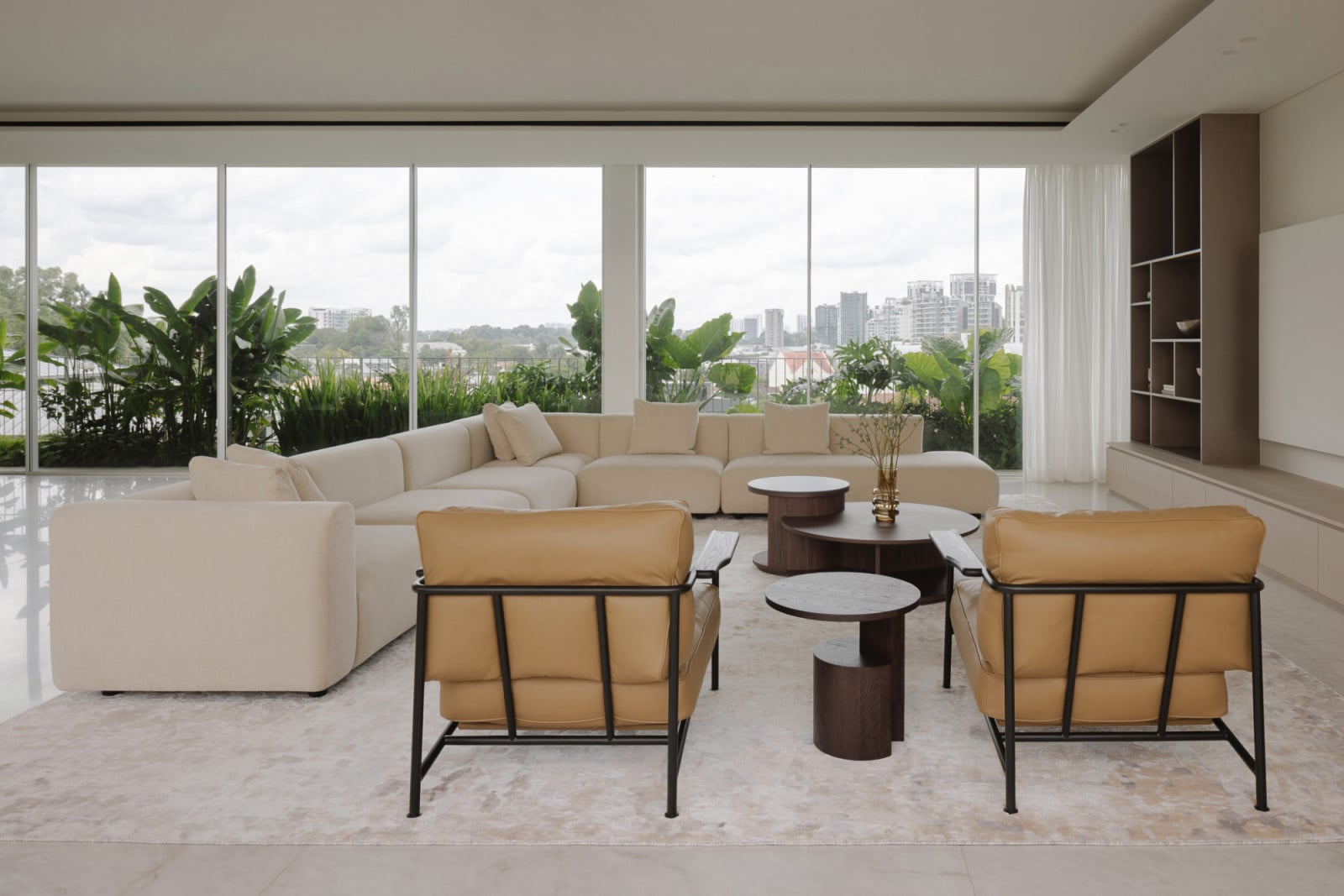 Expansive views of the city stretch beyond full-height glass windows in the generous living area