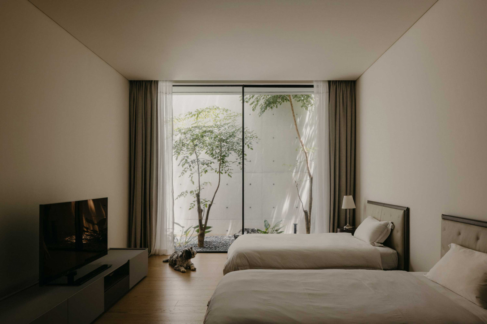 Framed by Classic’s Minimalist system, the bedroom becomes a quiet retreat where natural light filters gently through lush greenery