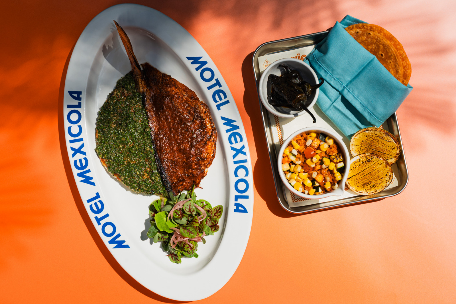 Pescado Los Cabos, a whole char-grilled snapper sheathed in salsa verde and smoked salsa roja