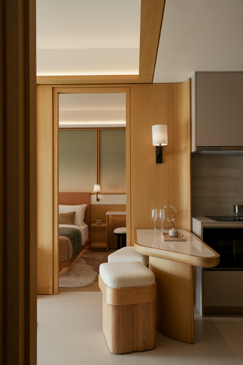 The kitchen island of the Type S unit, with a rounded marble top and boucle stools
