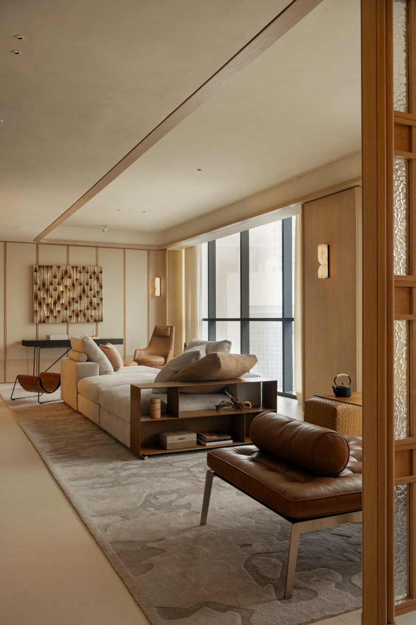 Wolo Experience Lounge curated by Ambient Living. The Flexform Groundpiece sofa anchors the main seating zone, accompanied by the Guscioalto armchair and the Bangkok ottoman. The Any Day writing desk sits against the upholstered wall panel, next to the Mate magazine holder and in the foreground sits the Magi chaise