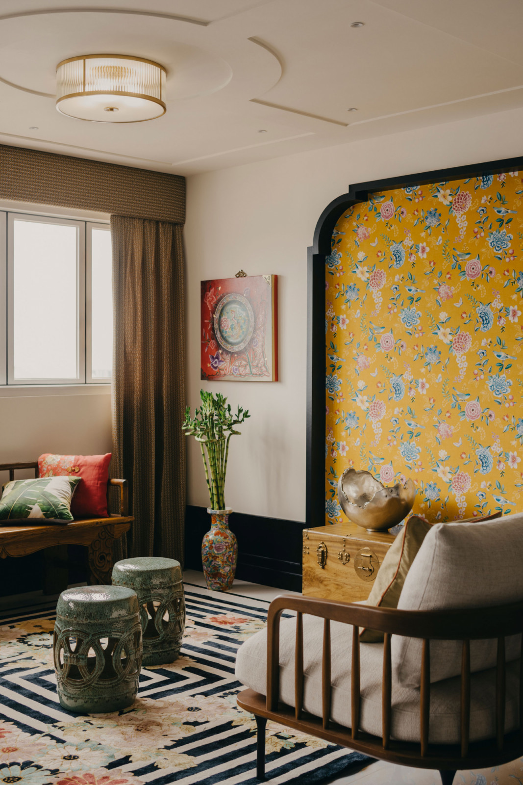 The living area was inspired by the atmosphere of a tea pavilion, anchored by a colourful chinoiserie-inspired rug and layered with antique Chinese furniture