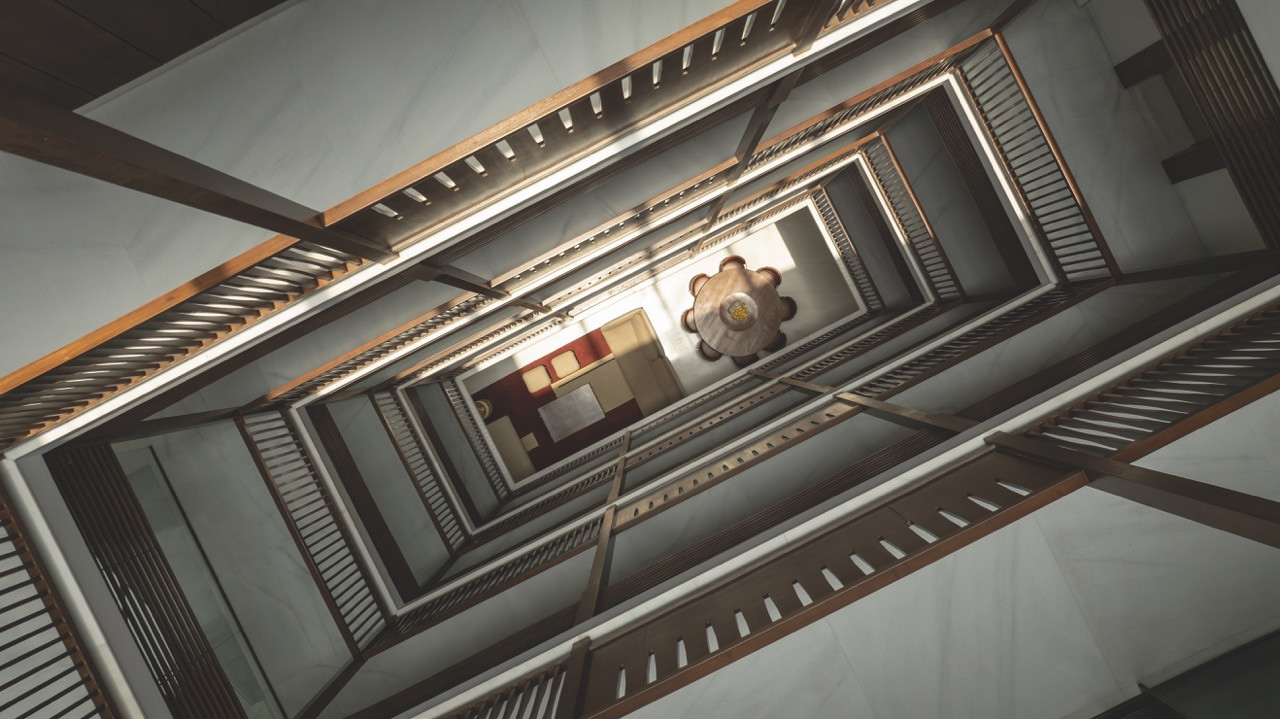 A view straight down the home’s central atrium, with the shadow cast by the skylight frame visible at the base