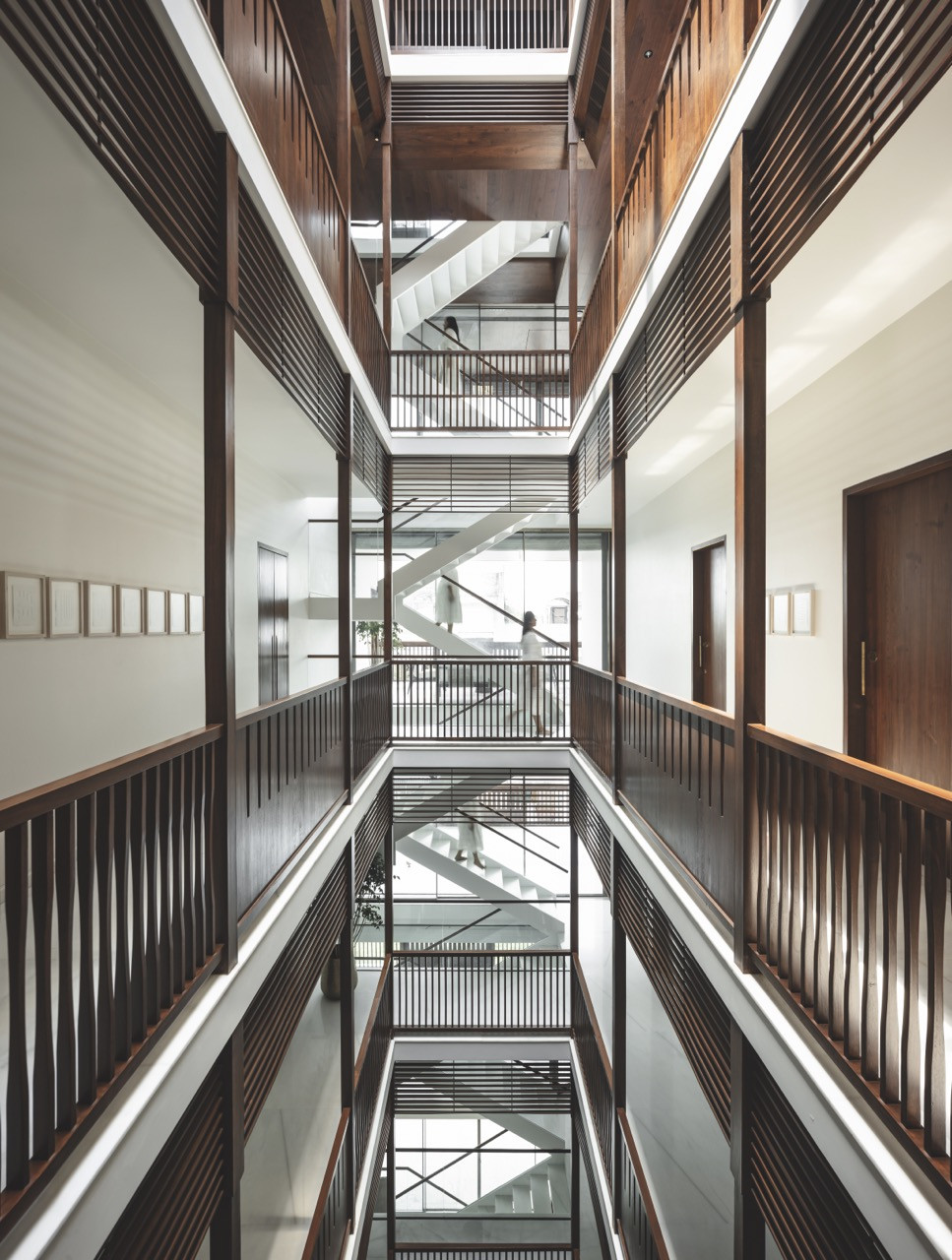 The voluminous atrium features teak railings and brise-soleil lining the corridors of each level