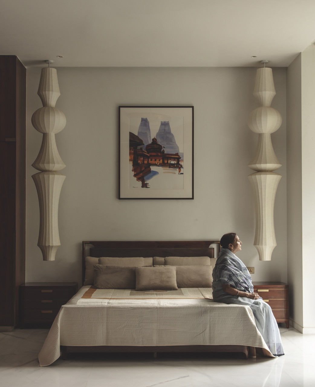 A bedroom in the grandmother’s suite, with sculptural hanging lamps flanking the bed