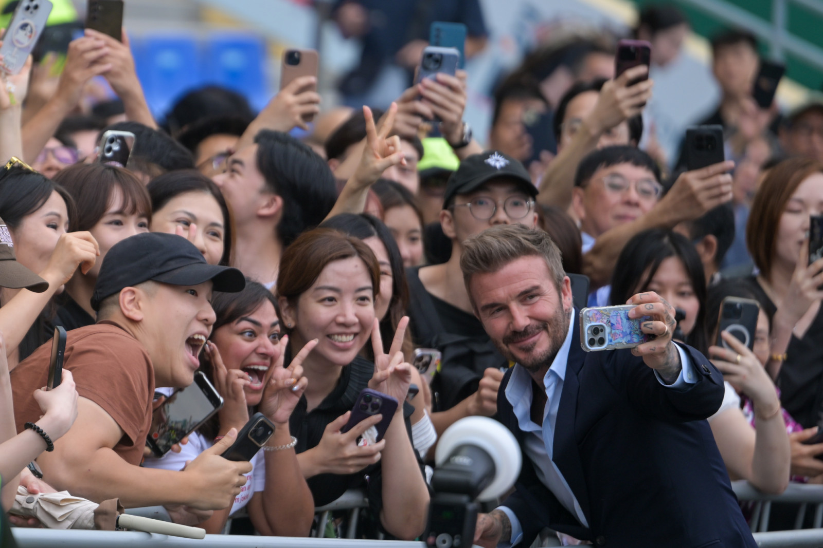 Football icon David Beckham takes a selfie with attendees during the "Racing with Football" event at Happy Valley Racecourse on June 10, 2026 in Hong Kong, China. With the 2026 FIFA World Cup just around the corner, this crossover event brings together football and horse racing enthusiasts, sparking a wave of sporting excitement across the city. (Photo by Chen Yongnuo/China News Service/VCG via Getty Images)