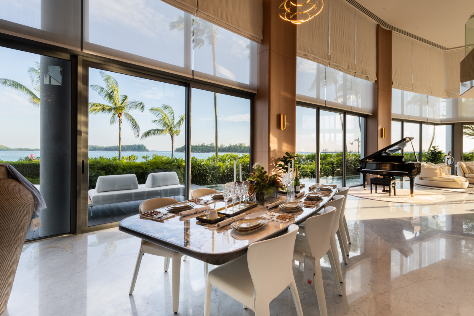Floor-to-ceiling glazing frames an uninterrupted view of the Sentosa Cove waterfront in this dining space by ARTG Design Group's Architology Interiors