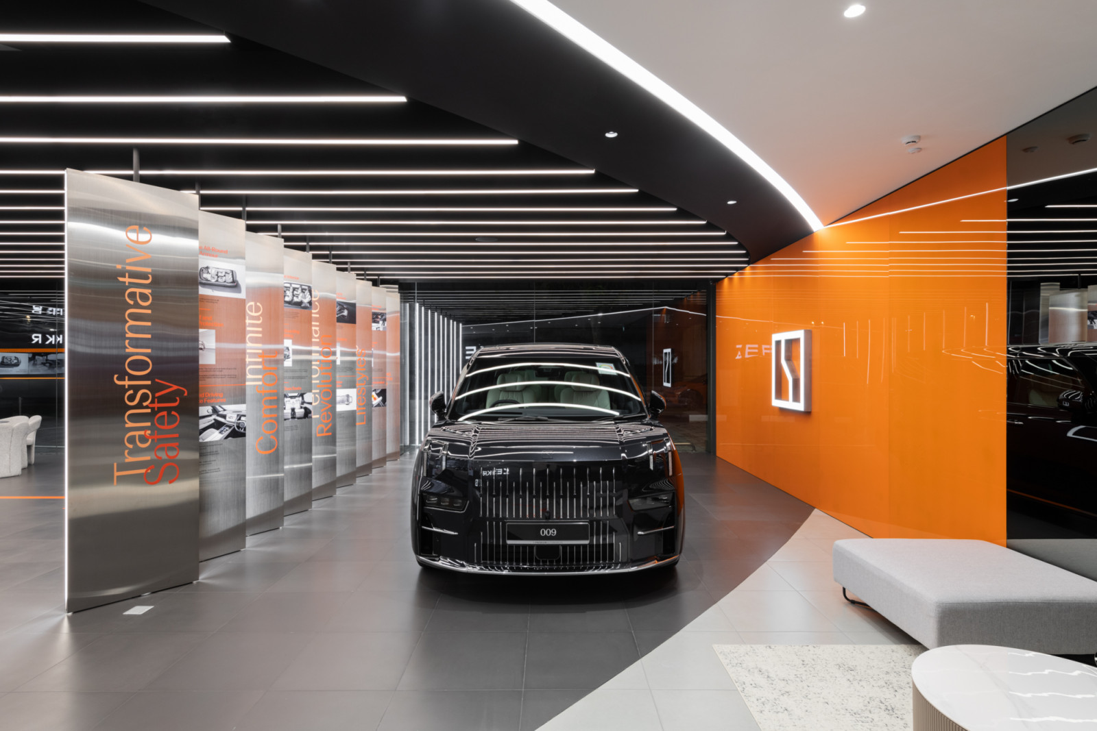 Aarticle transforms the Zeekr Centre Singapore into an immersive brand experience, with illuminated steel panels, bold orange accents, and dramatic linear lighting framing the marque's flagship 009 model
