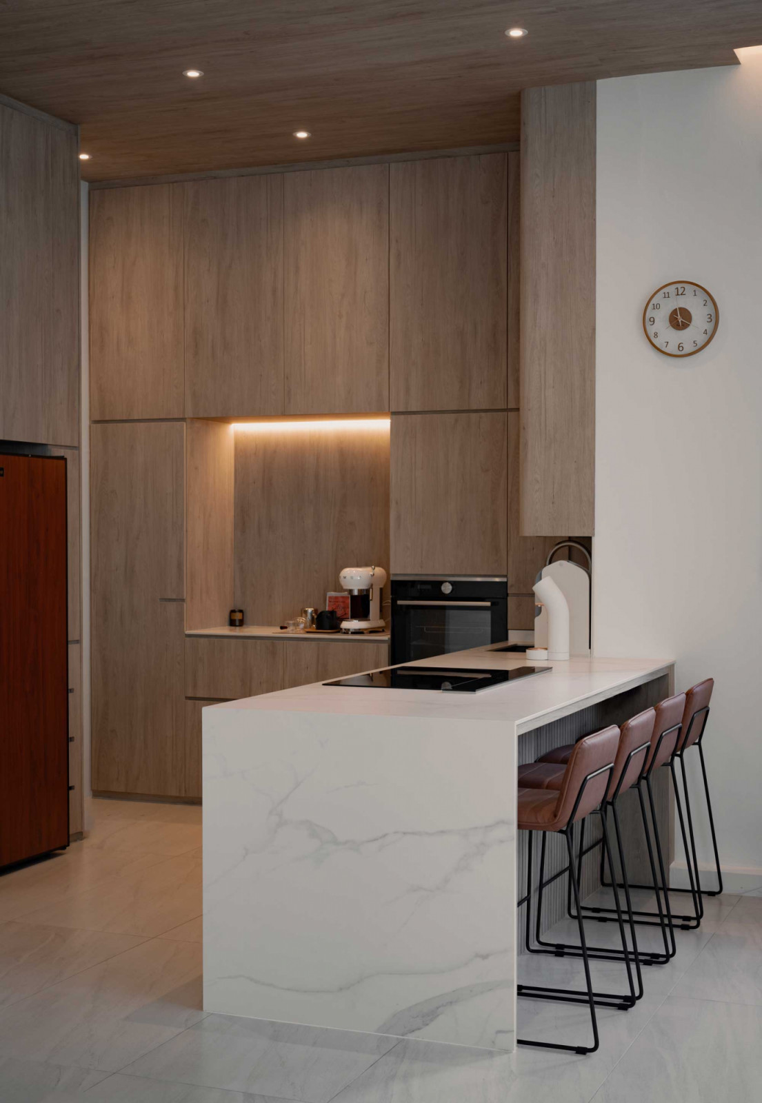 The kitchen pairs a marble island with warm timber cabinetry