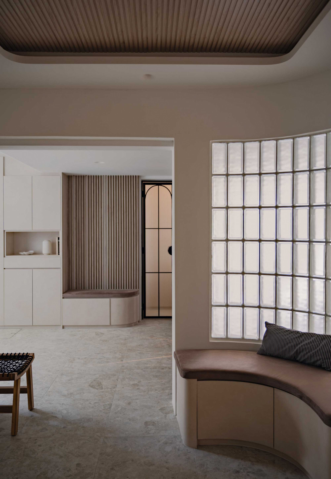 Curved built-ins and a glass-block wall soften this space