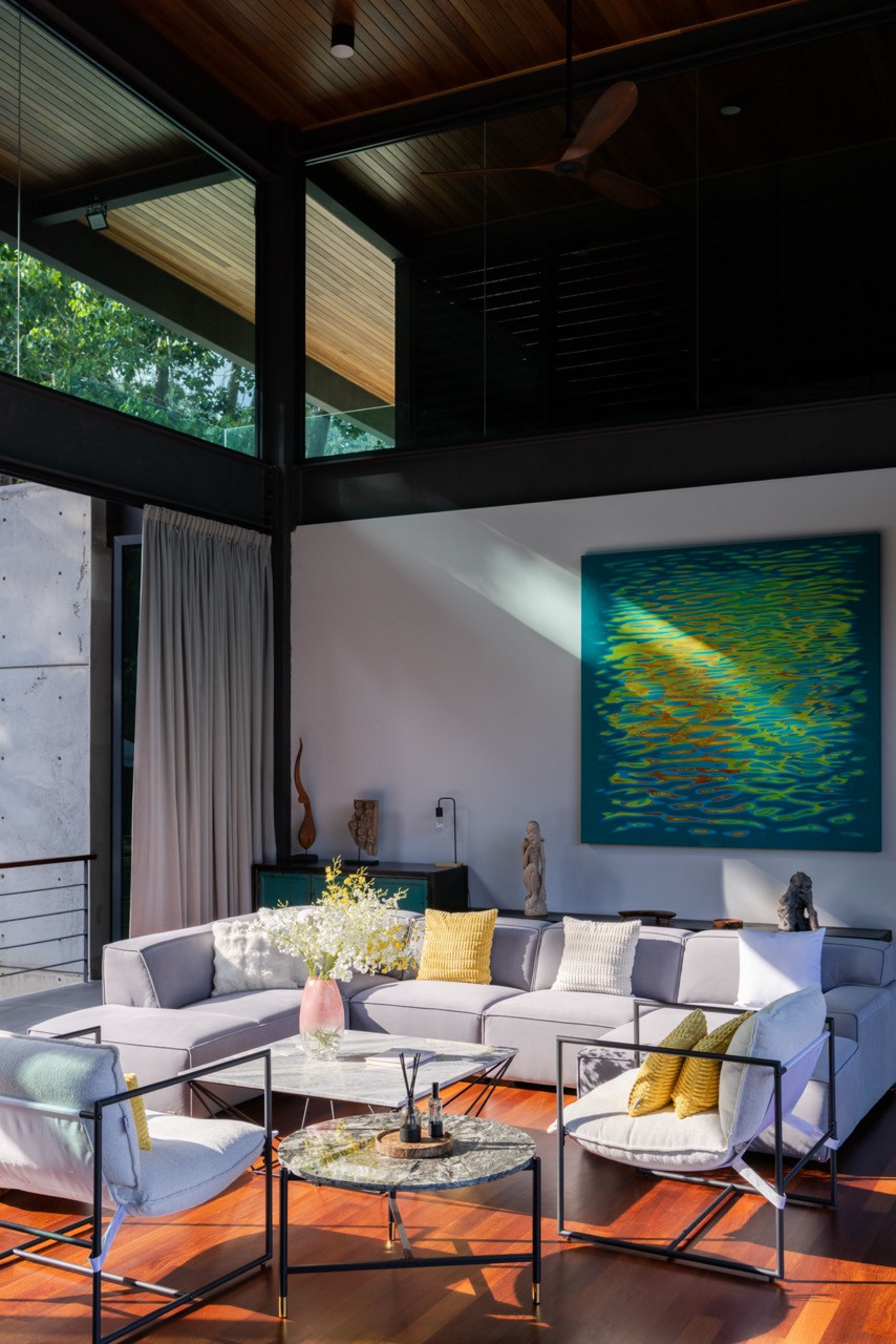 The living room, with ceilings reaching an average of six metres, nyatoh timber cladding overhead and merbau timber flooring below