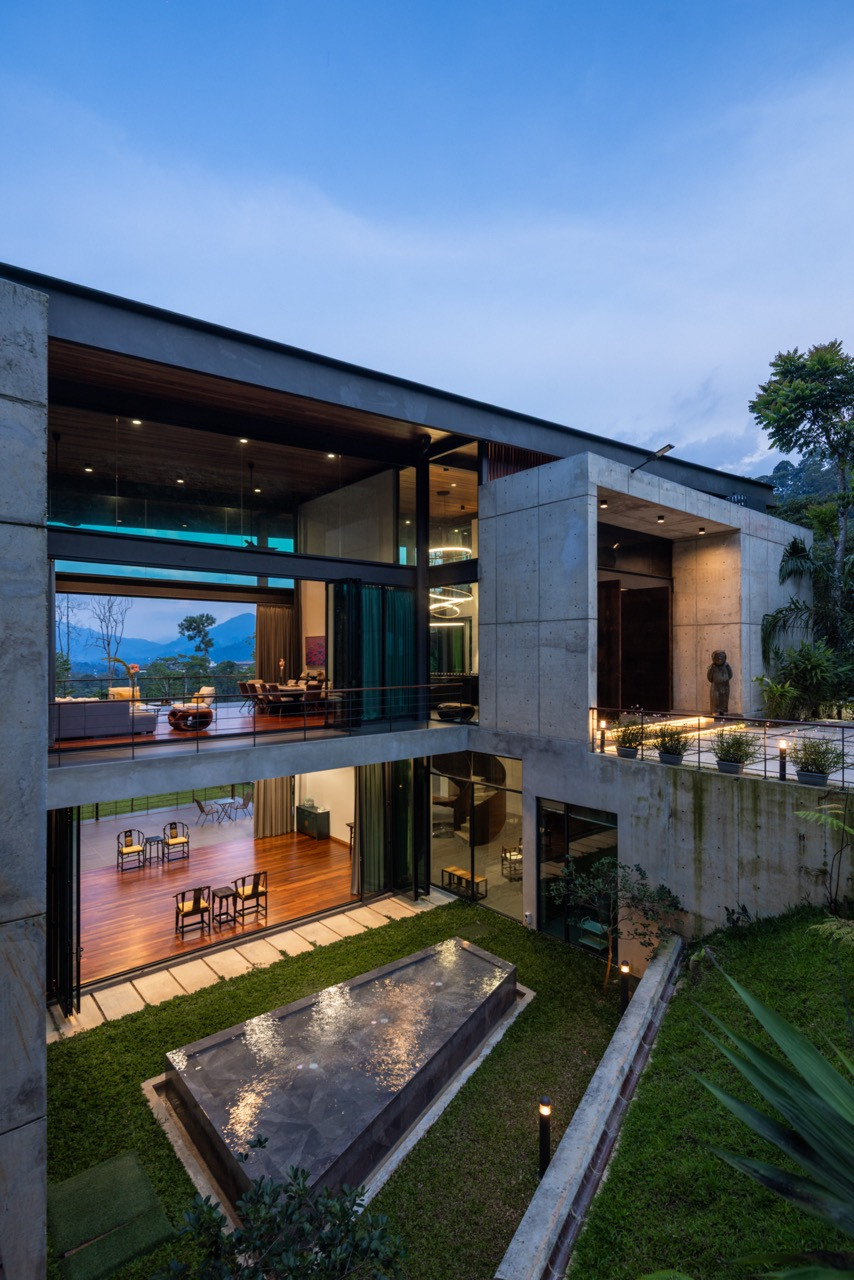 The rear elevation at dusk, showing the off-form concrete walls and the back courtyard’s reflecting pool