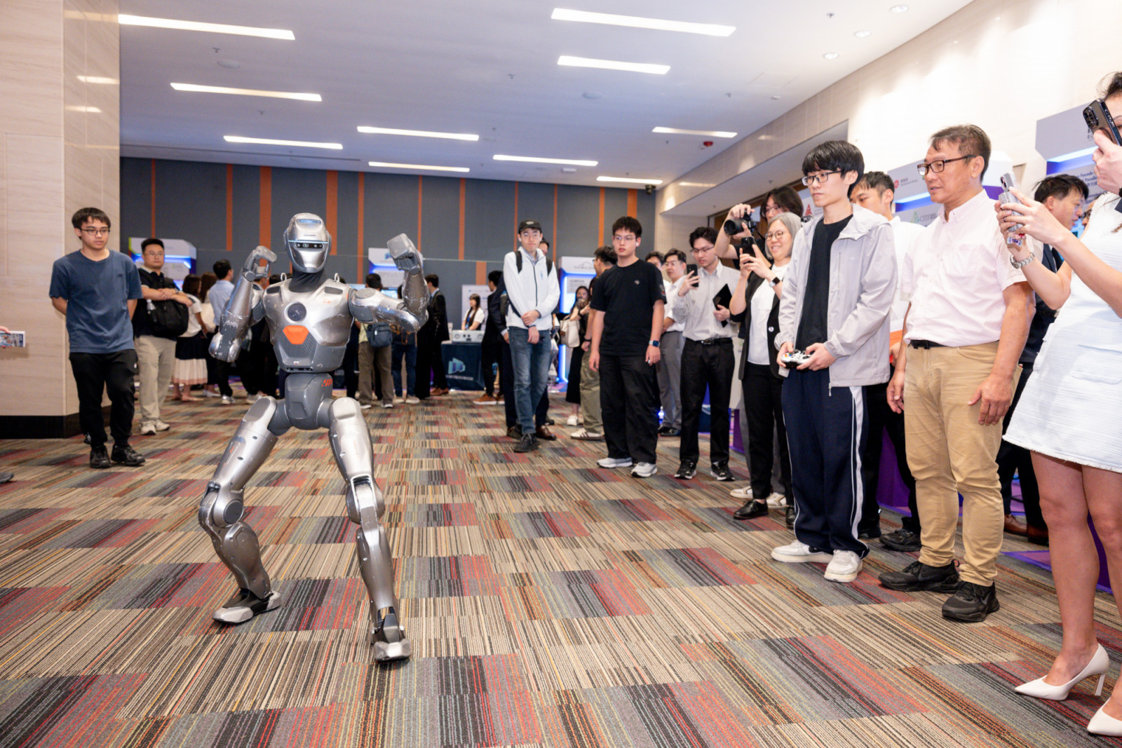 A humanoid robot draws a crowd in a demonstration at the CIC Global AI and Smart Construction Conference and Exhibition (GASCCE) 2026. (Photo: CIC)