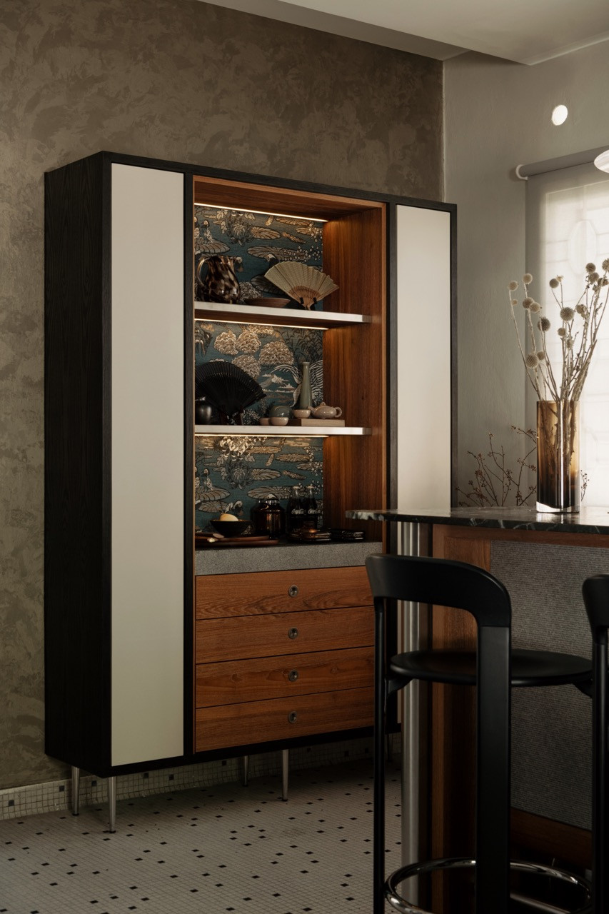 The custom freestanding cabinet opens to reveal a walnut interior lined in decorative fabric