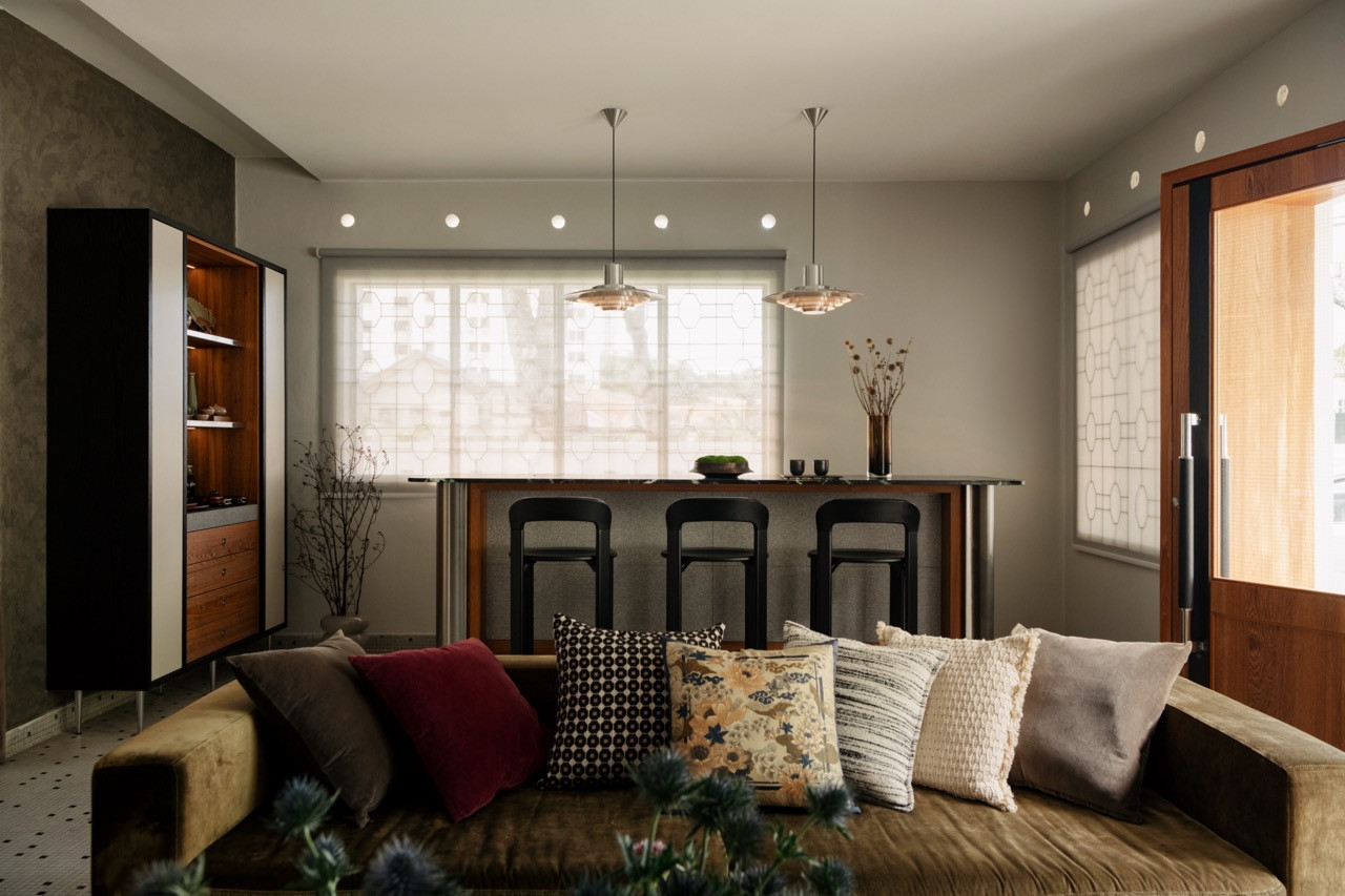 PH5 pendants hang above the dark stone counter with original octagonal window grilles running across the back wall