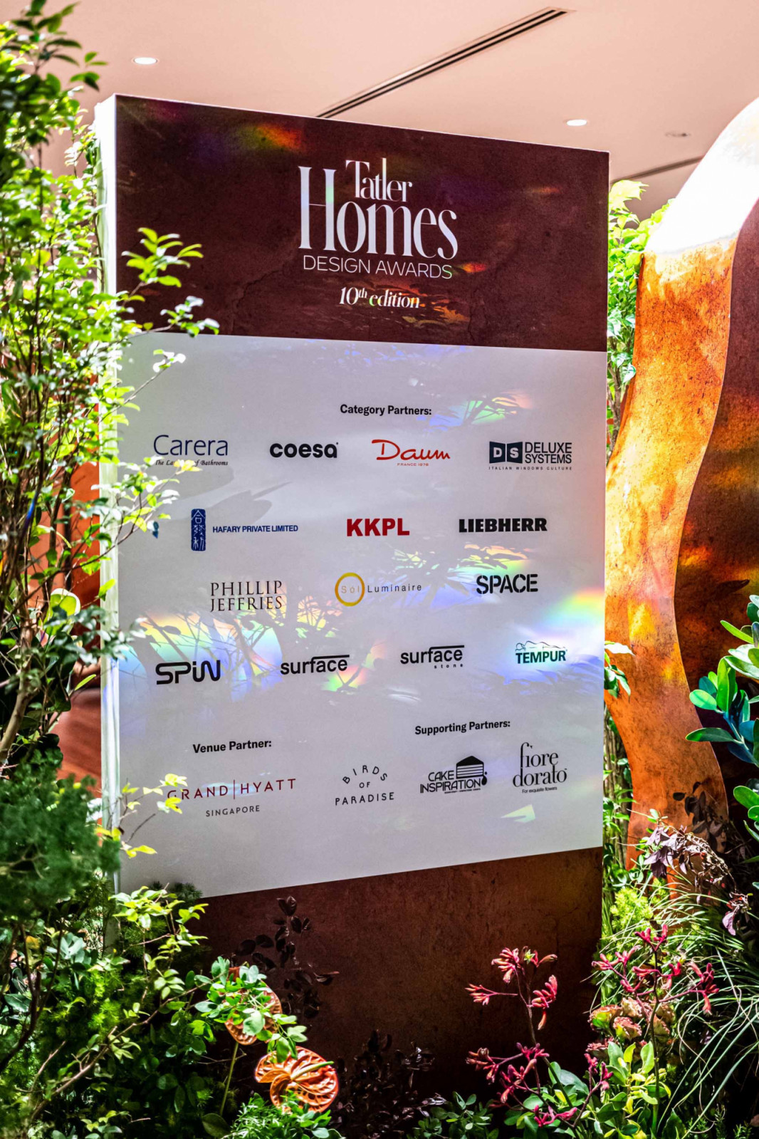 The sponsor walls featuring Carera Bathroom, Coesa, Daum, Deluxe Systems, Hafary, KKPL, Liebherr, Phillip Jeffries, Sol Luminaire, Space Furniture, Spin Fans, Surface Project, Surface Stone, Tempur, Grand Hyatt Singapore, and supporting partners , Birds of Paradise, Fiore Dorato, Laderach and Flaming Queen