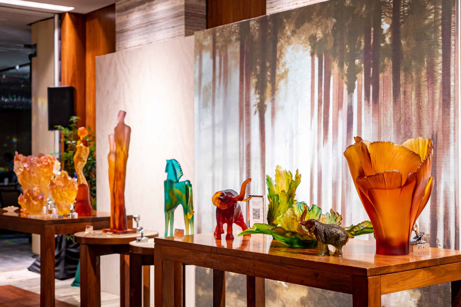 Daum collections beautifully displayed with Phillip Jeffries wallpaper in the background