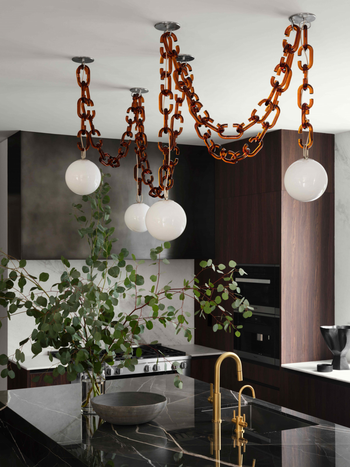 A Trueing Studio pendant while natural stone plays a significant role in the kitchen area