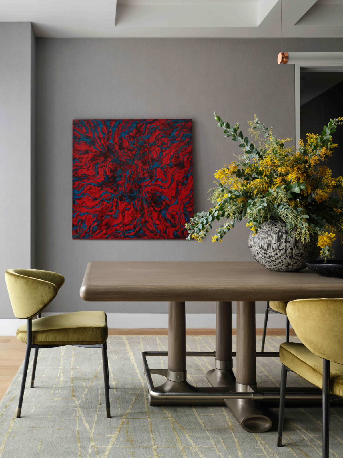 The timber dining table with a custom bronze foot rail is framed by Minotti Mills chairs