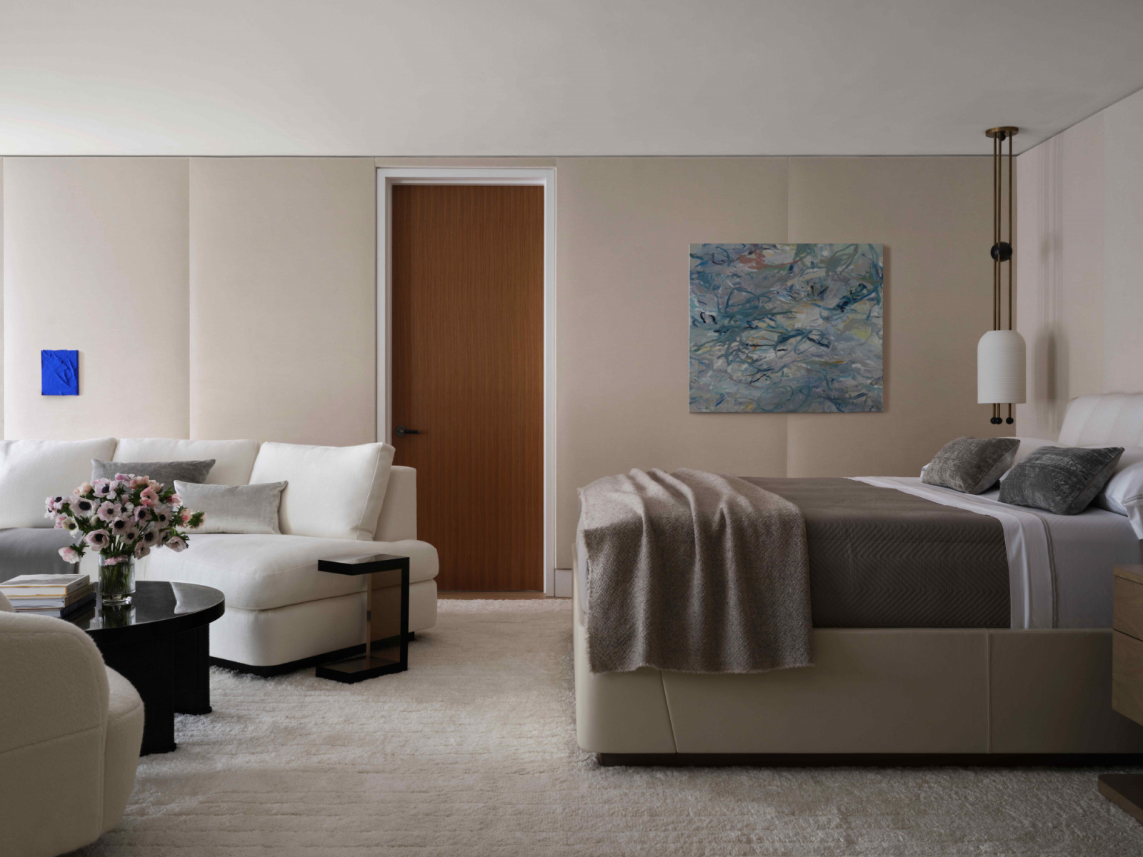 The primary suite with upholstered wall panels and a Holly Hunt bed