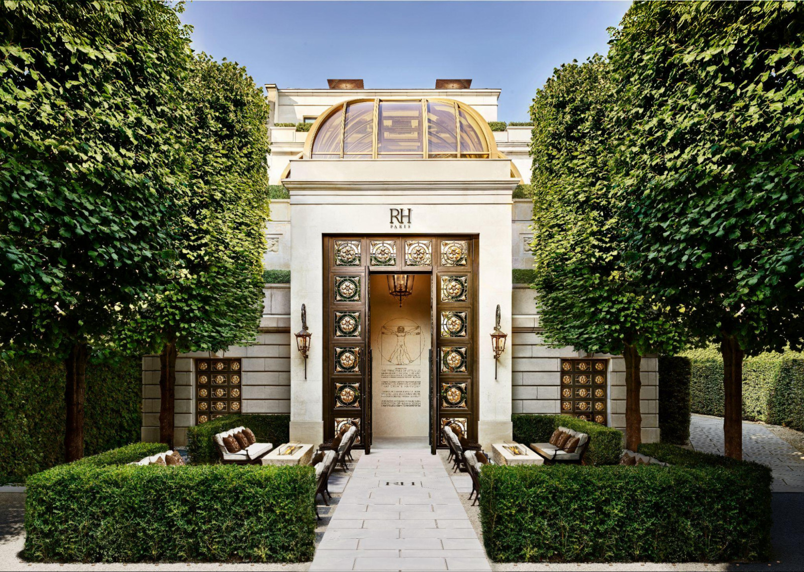 The entrance at 23 Avenue des Champs-Élysées is framed by clipped trees and bronze doors engraved with Leonardo da Vinci’s Vitruvian Man, a reference to the Vitruvius text held in the building’s library (Photo: Kristen Pelou)
