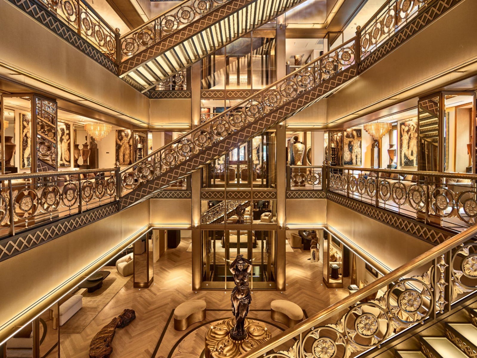 Bronze staircases crisscross a multi-storey atrium, its balustrades patterned with rosette and lattice motifs (Photo: Kristen Pelou)
