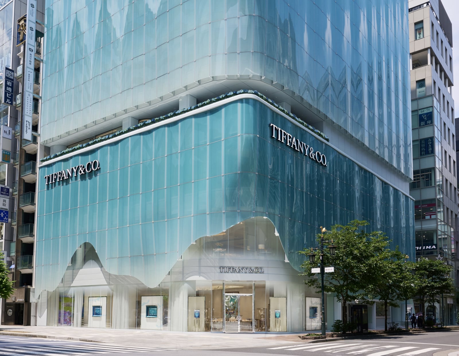 The tower’s wave-form glass façade, designed by Jun Aoki, shifts between clear and Tiffany blue across its surface