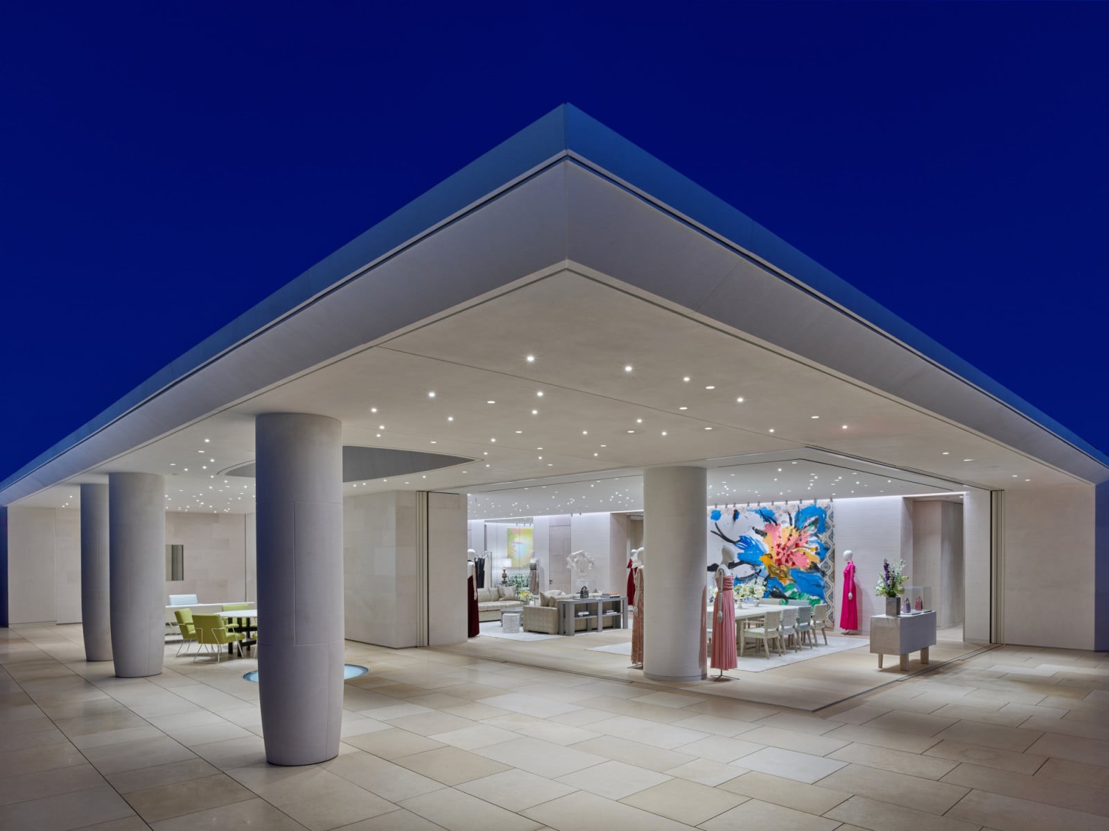 At dusk, the rooftop terrace’s angular overhang extends over a paved outdoor space, its underside lit with recessed lighting (Photo: Jonathan Taylor)