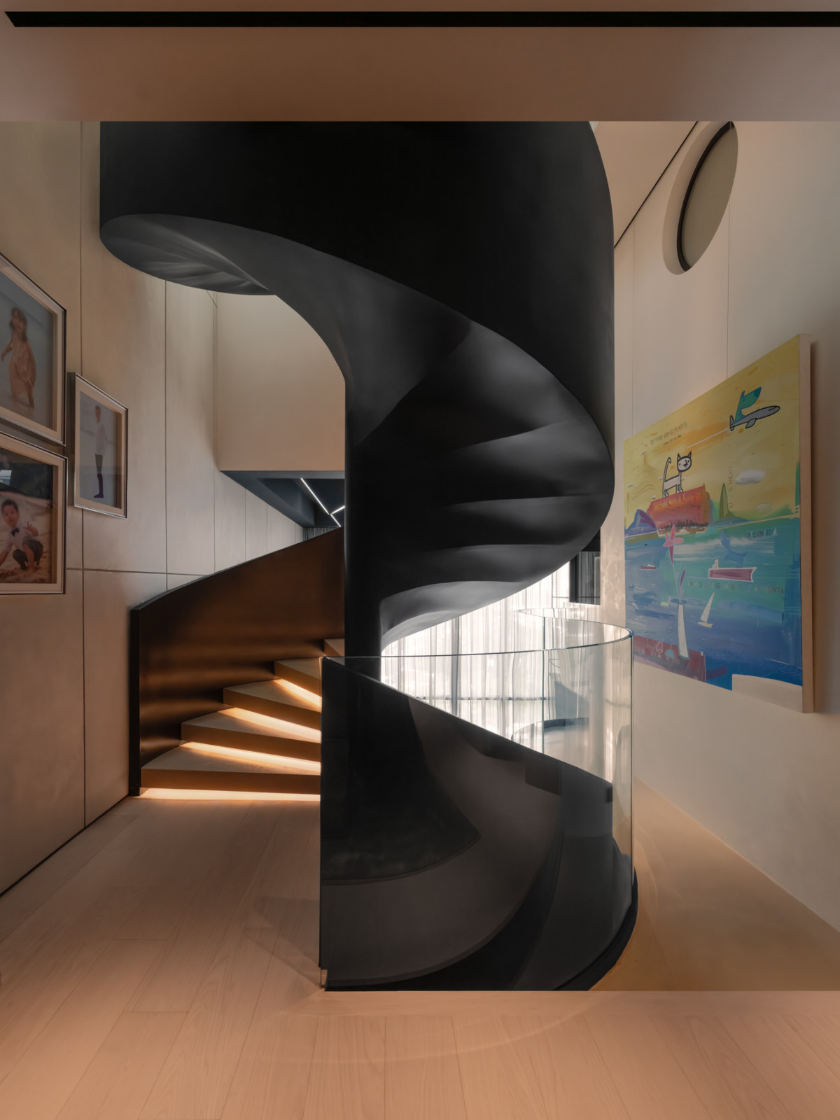 The rubber-oiled steel spiral staircase, with timber treads lit from below