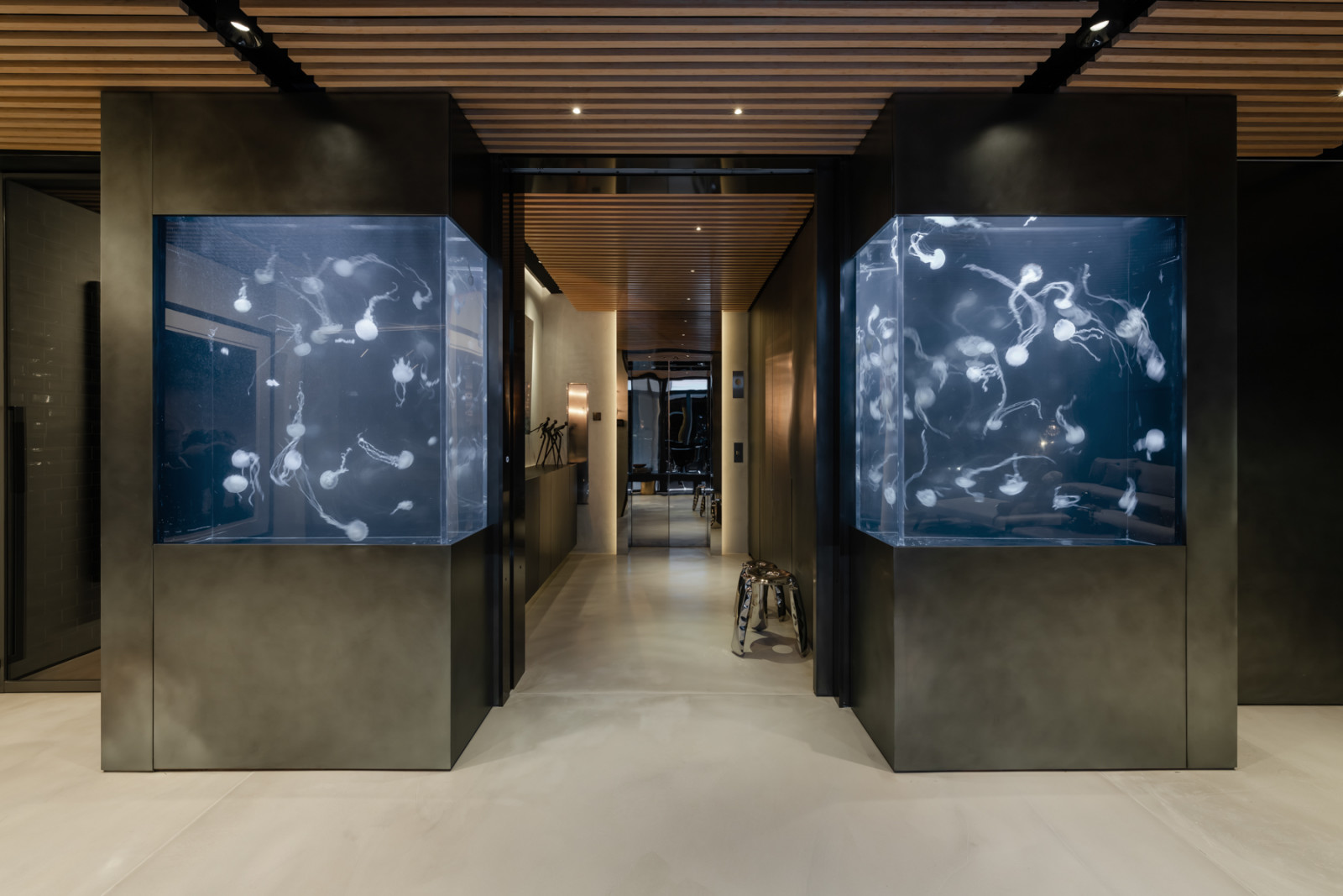 The entrance jellyfish tanks at night, their illuminated forms casting an otherworldly light across the foyer corridor