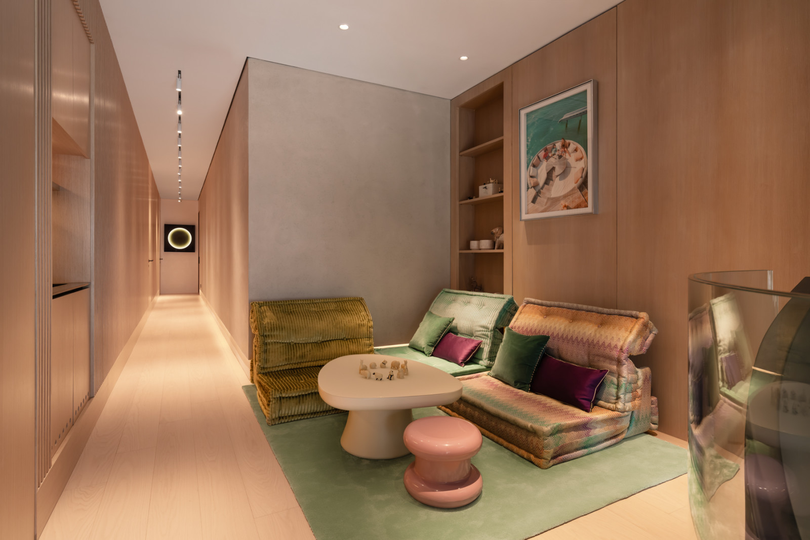 The children’s playroom on the first floor, warm in timber panelling throughout, is furnished with low-slung corduroy and patterned seating around a kidney-shaped table