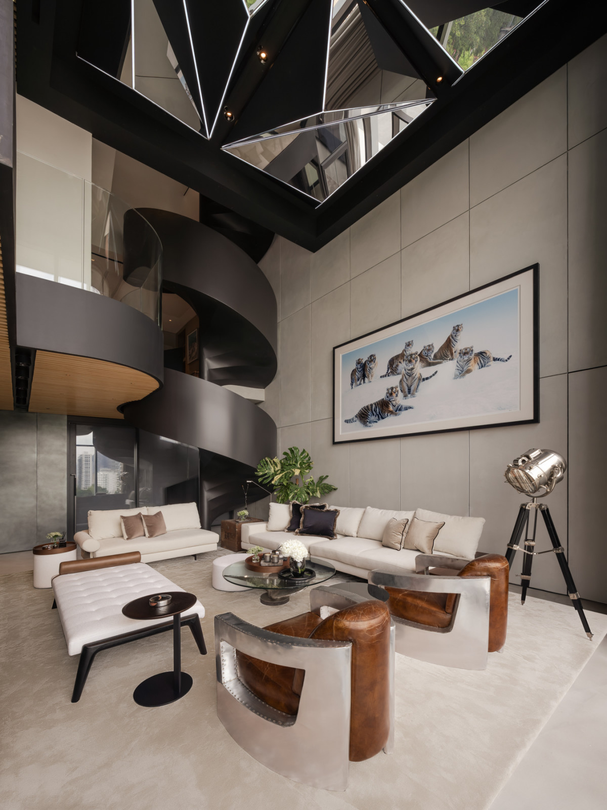 Angular Barisol mirrors set into stretched fabric on the double height ceiling add an industrial counterpoint to the bamboo slat sections and cream upholstery of the room below