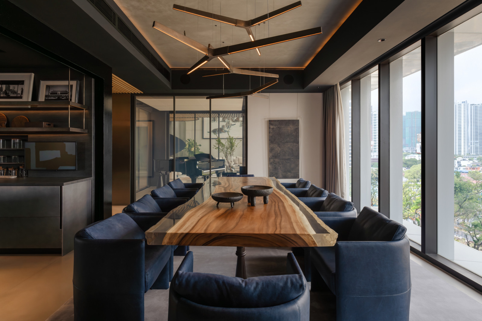 The reclaimed wood dining table, is lit by Henge Italy pendants and flanked by blue leather chairs
