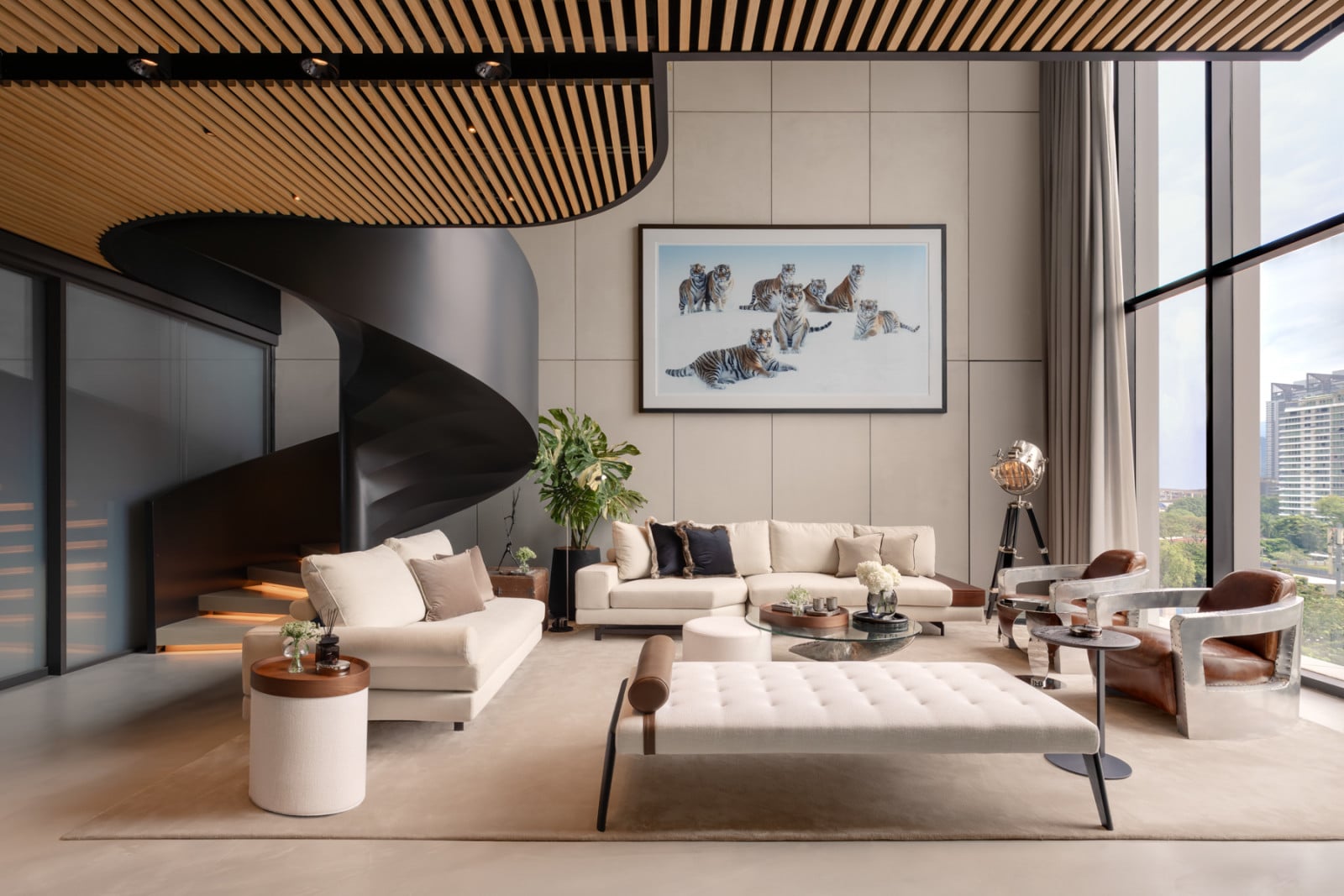 The double-height family room, with Japanese-inspired bamboo slat ceiling sections masking the lighting and sound system, is anchored by cream upholstery and Timothy Oulton furniture sourced for the project