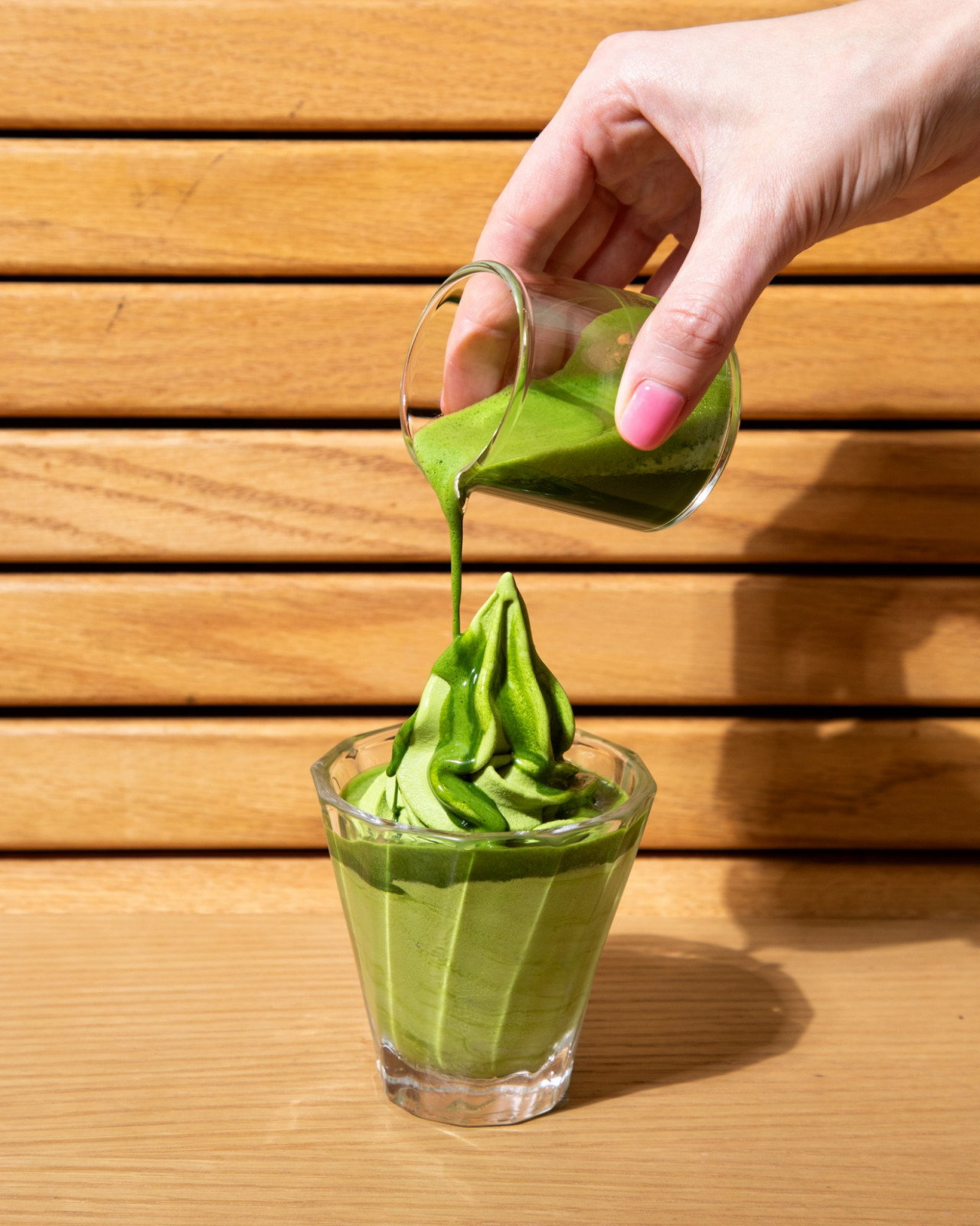 A generous pour of vibrant matcha sauce cascades over rich matcha soft serve ice cream at Matchali.